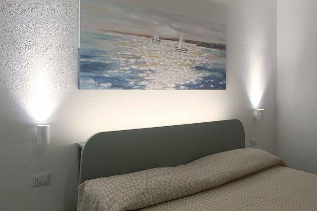 Testiera del letto con quadro e luci.