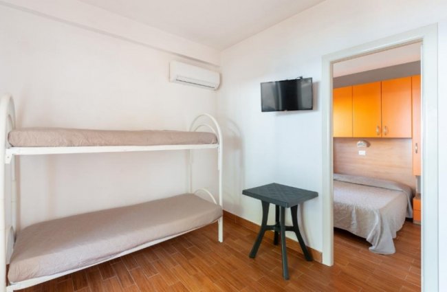 Letti a castello in una stanza con TV a schermo piatto.