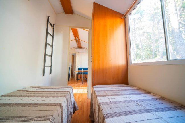 Camera con due letti singoli e finestra grande.