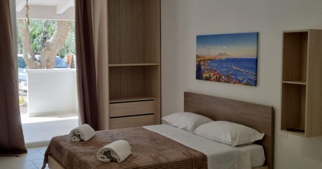 Camera d'albergo con letto matrimoniale e balcone.