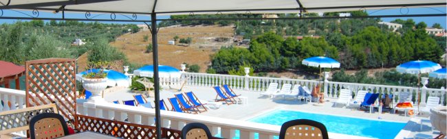 Piscina con lettini e ombrelloni.