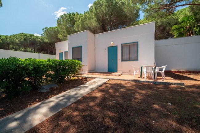 Villetta bianca con porta blu e area patio.