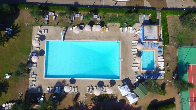 Piscina e area lettini vista dall'alto, ombre e lettini.