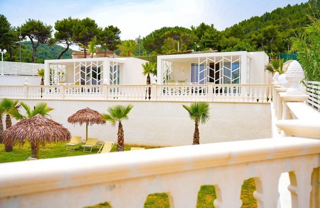 Bungalows moderni con terrazza e palme.