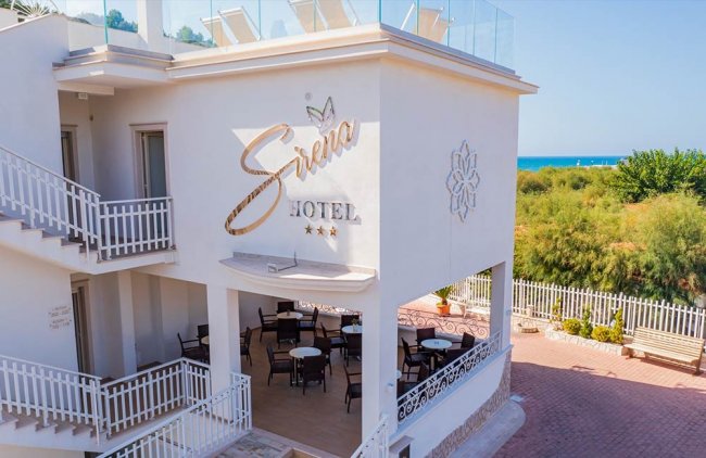 Facciata di un hotel bianco vicino al mare.