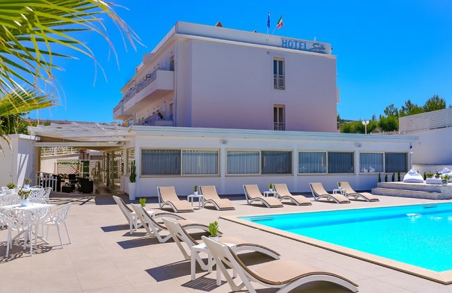 Hotel con piscina e lettini.