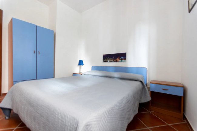 Camera con armadio blu e lampada accesa.